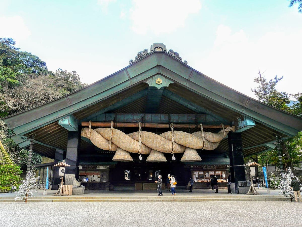 Ang harapan ng Kaguraden bulwagan sa Izumo Taisha na may napakalaking pilipit na dayami shimenawa na lubid na nakasabit sa pasukan nito sa ilalim ng berdeng tansong bubong