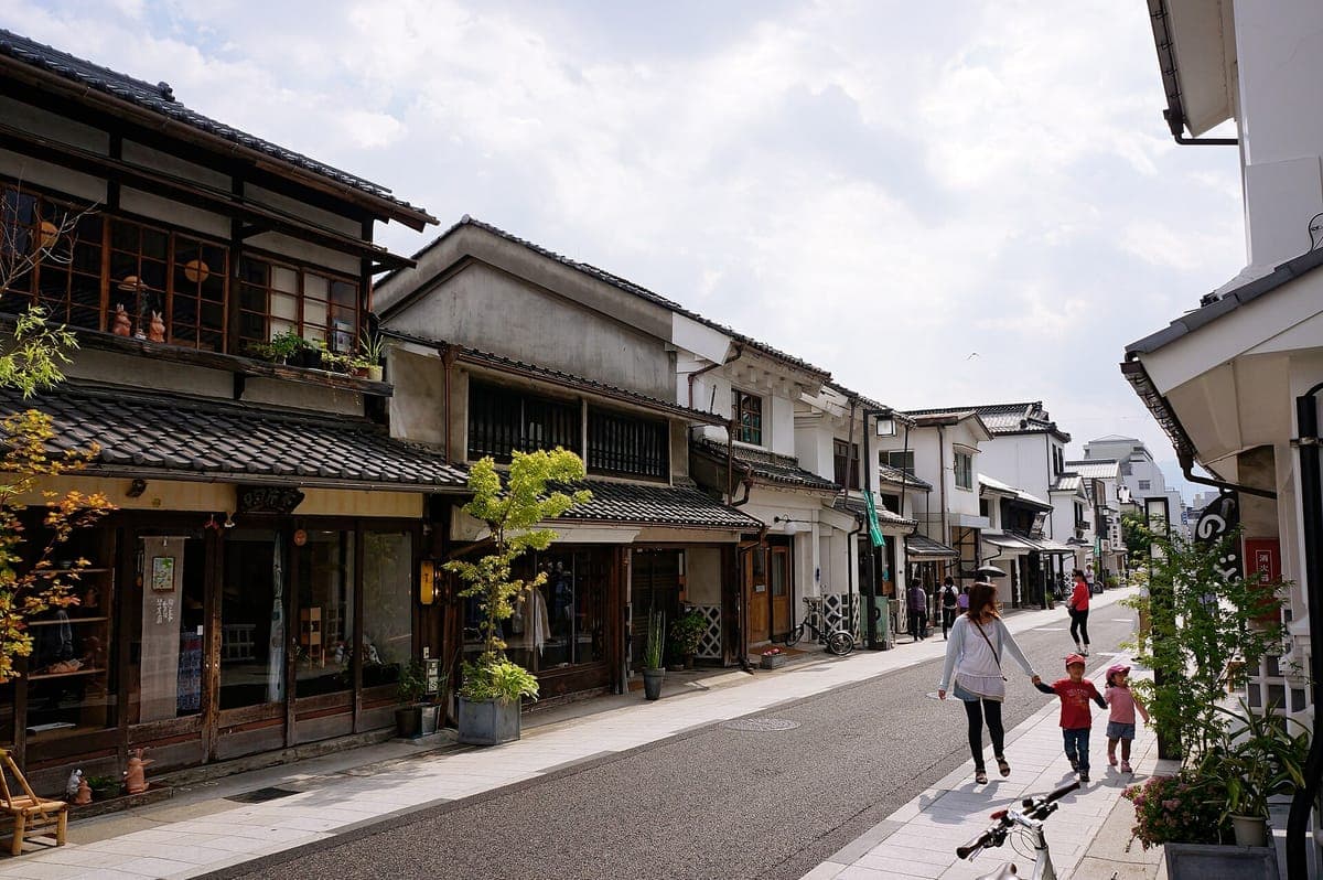 Die Nakamachi-Straße in Matsumoto ist gesäumt von weißgemauerten Lagerhäusern mit schwarzen Ziegeldächern und kleinen Läden, in der ein paar Leute spazieren gehen