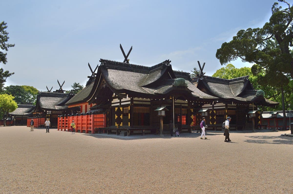 Ang mga pangunahing bulwagan ng Sumiyoshi Taisha na may madilim na tuwid na gable na bubong, crossed roof beam at vermilion na bakod, na nakatayo sa isang malawak na gravel courtyard