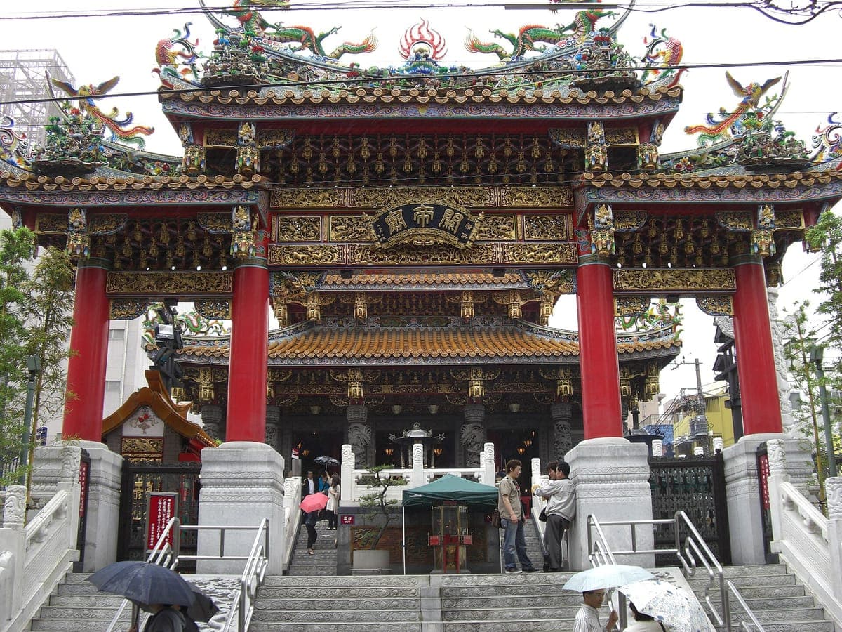 Ozdobna Kanteibyō świątynia w Yokohama Chinatown, z czerwono-złotą bramą, figurami smoków na dachu i białymi kamiennymi schodami prowadzącymi do sali