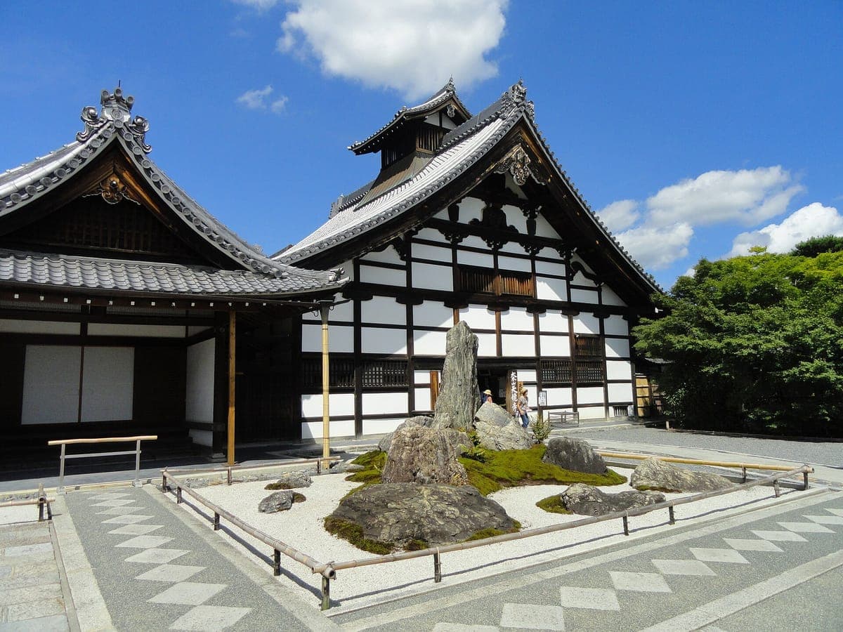 El Kuri de Tenryū-ji, de paredes blancas y madera oscura, con su alto hastial curvo, detrás de un pequeño jardín rastrillado con una piedra erguida